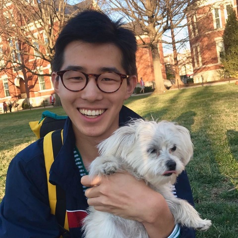 Sean Wu smiling and holding his small dog