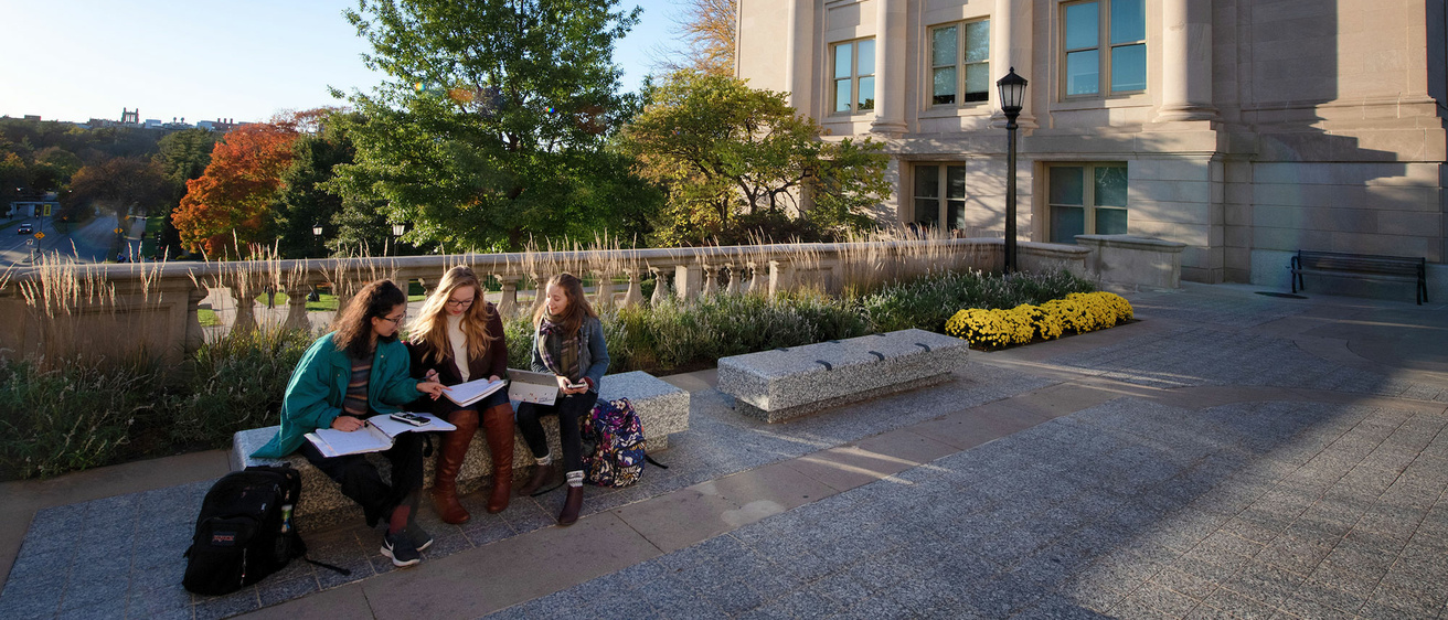 students meeting on a bench