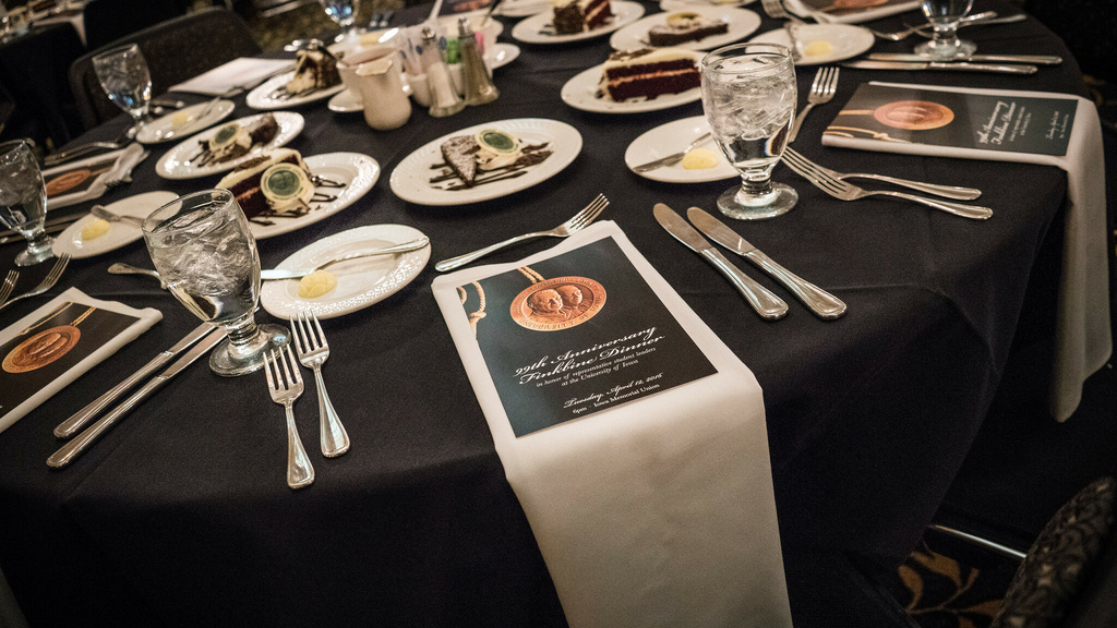 A table with plates in the IMU main lounge and a placard describing the Hancher-Finkbine Awards